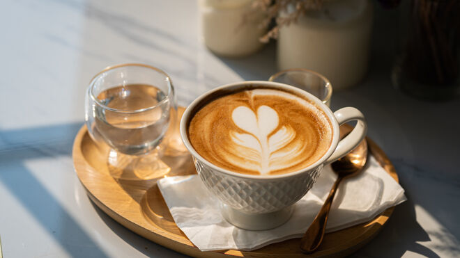 Tasse Kaffee und ein Glas Wasser | Getty Images / Thinnapob