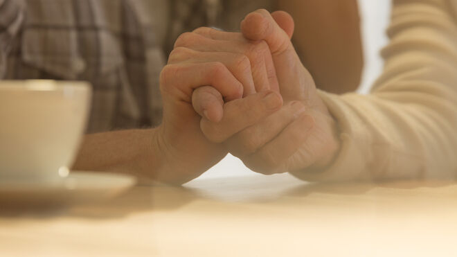 Eine jüngere Hand umgreift eine ältere Hand | GettyImages / KatarzynaBialasiewicz