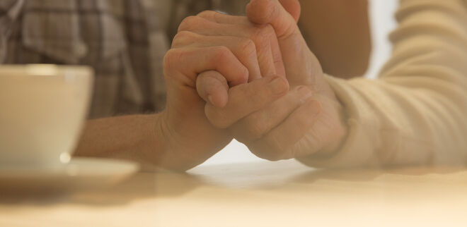 Eine jüngere Hand umgreift eine ältere Hand