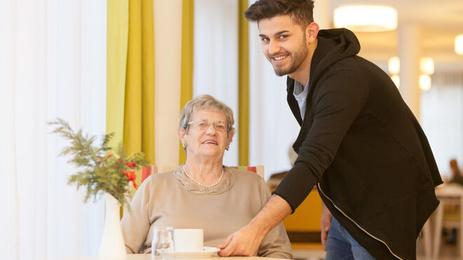 Zivildiener reicht einer Frau einen Kaffee | FSW